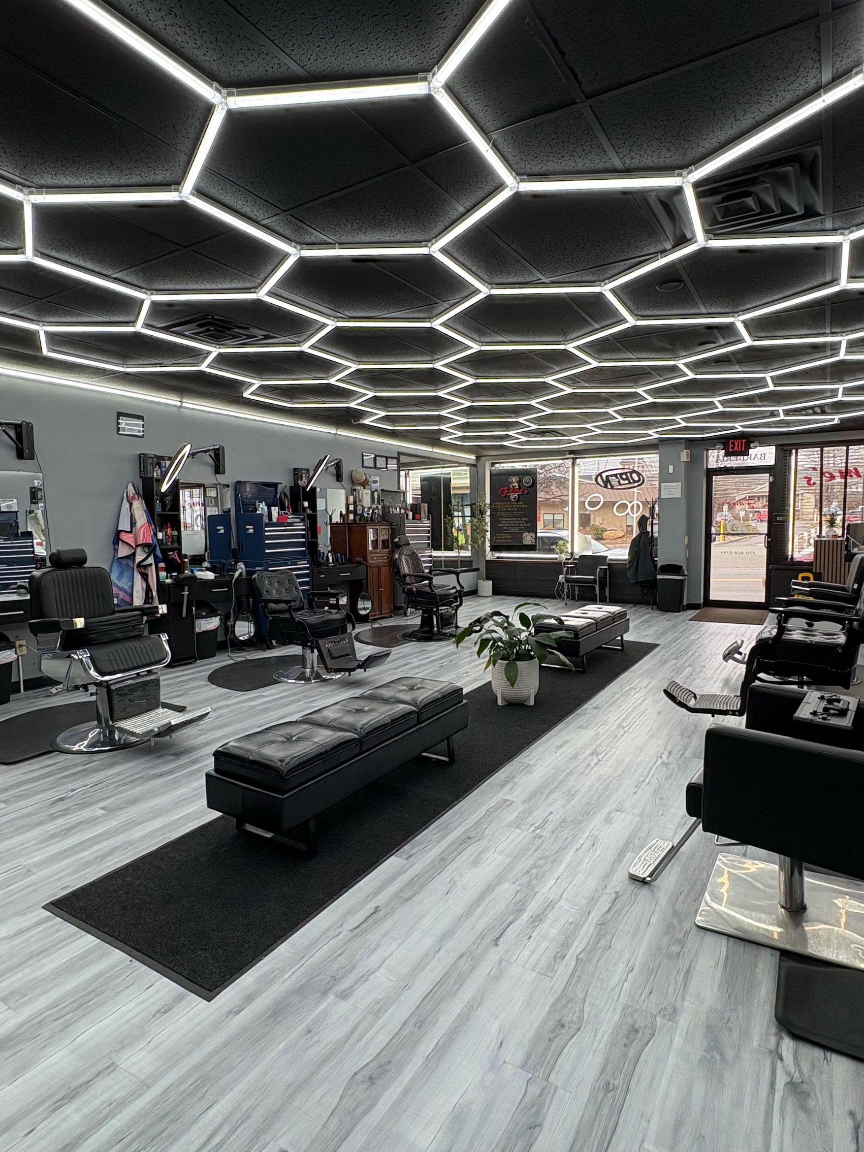 Vertical view inside Fame's Barbershop showing the full depth of the shop, multiple barber stations, and the detailed interior decor